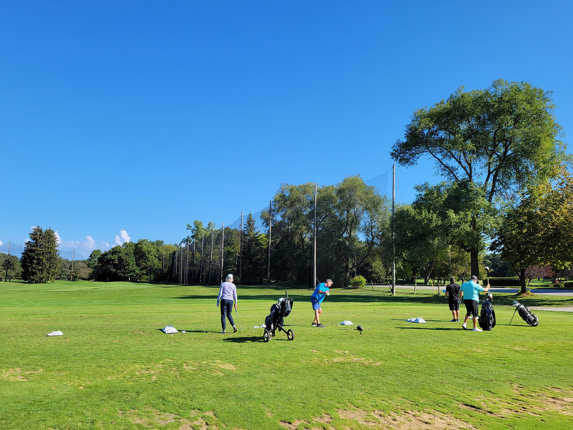 golfers on driving range hor